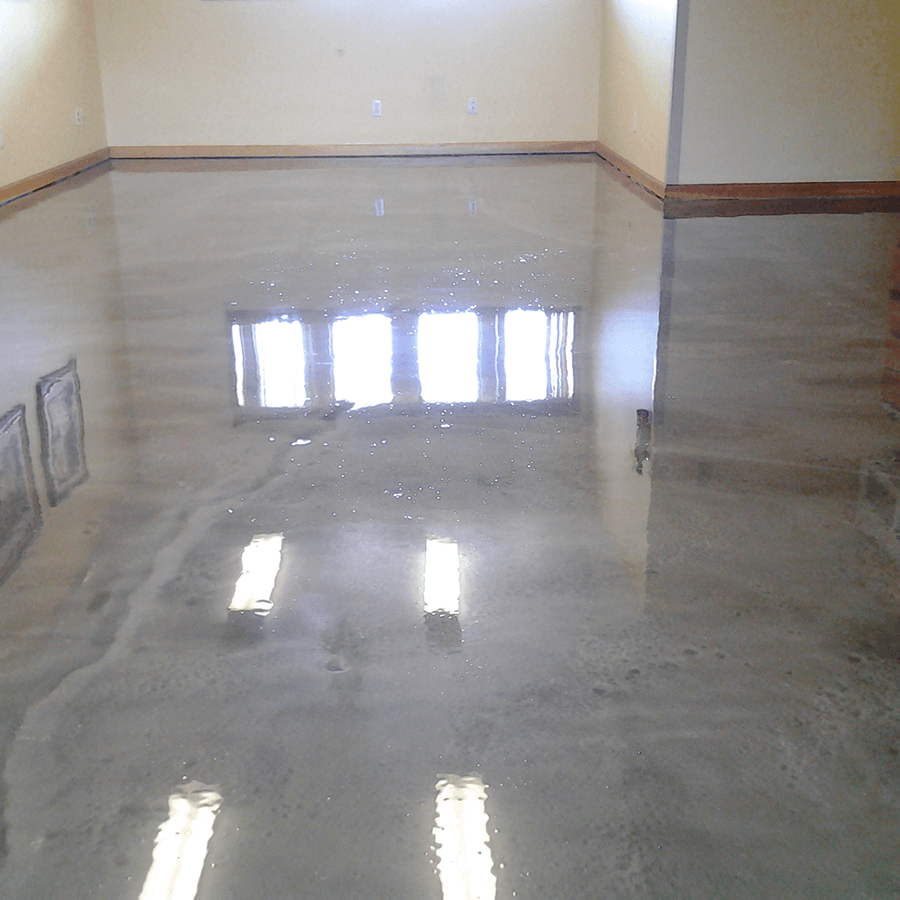 a shiny concrete floor in a room with windows reflected in it