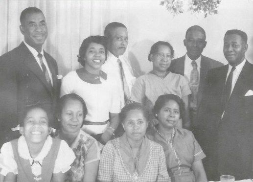 A black and white photo of a family posing for a picture.