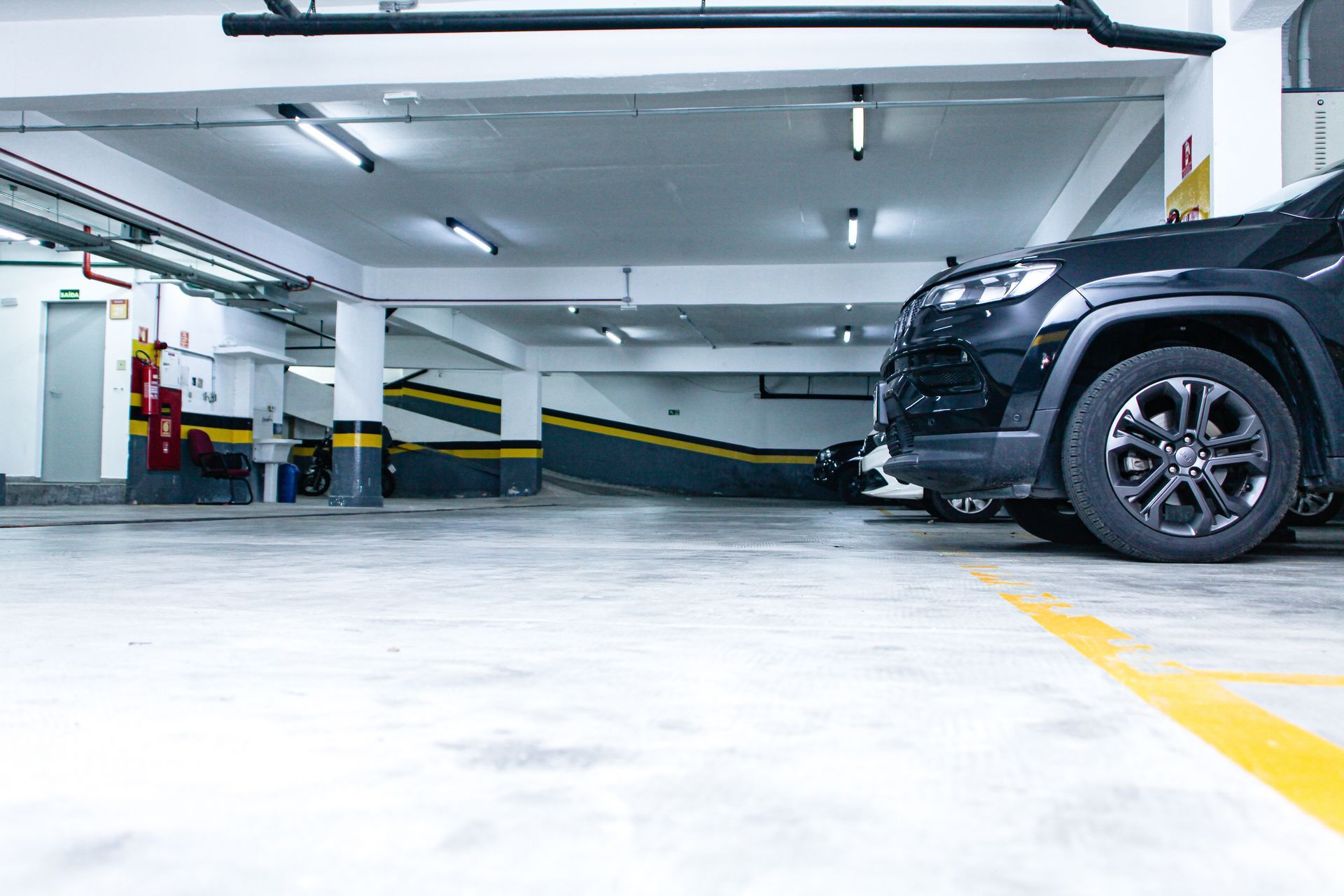 Um carro preto está estacionado em uma garagem. Hotel Solar Paulista