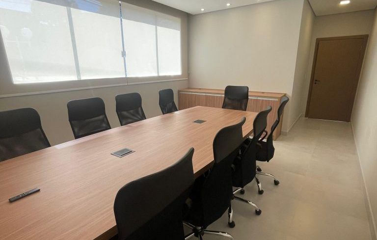 Uma sala de conferências com uma longa mesa de madeira e cadeiras pretas Hotel Solar Paulista 