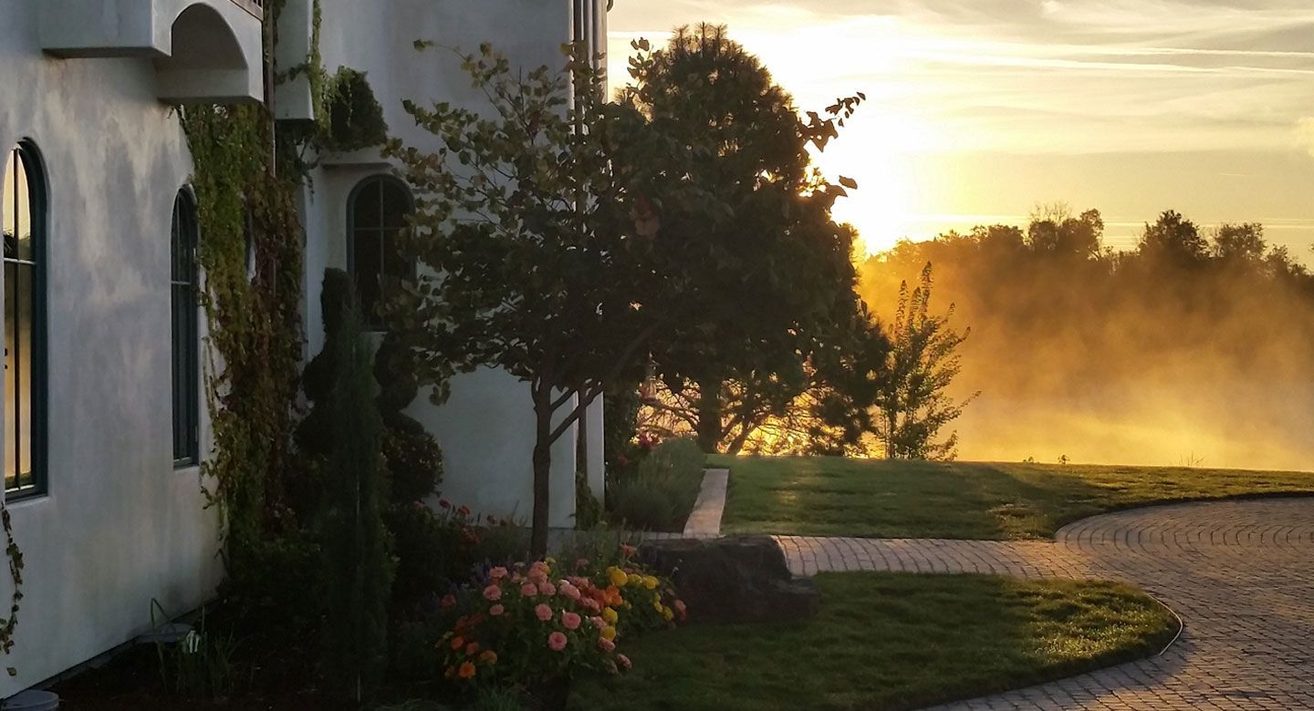 A house with a driveway and a sunset in the background