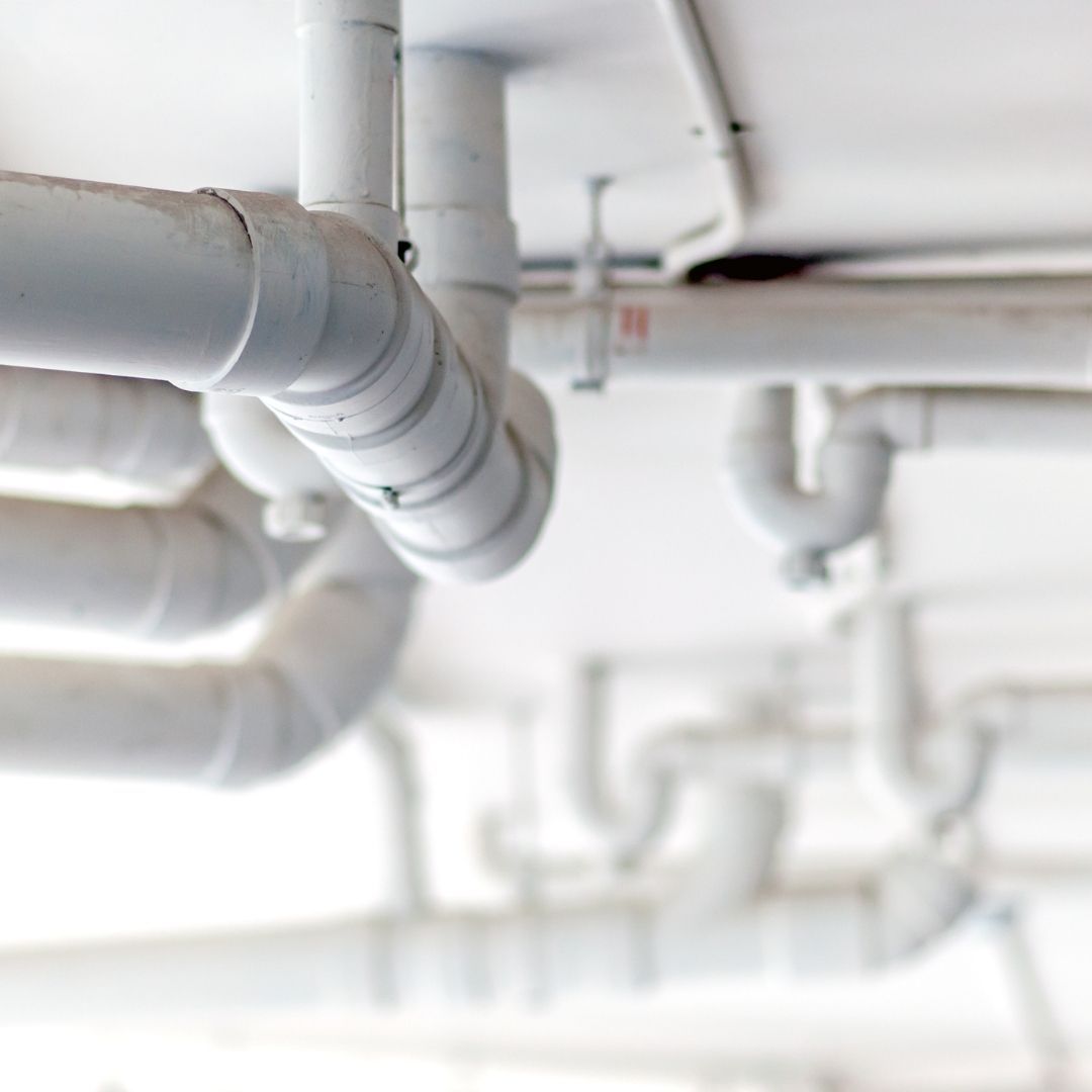 A Bunch of White Pipes are Hanging From the Ceiling — Wigg Plumbing in Berrimah, NT