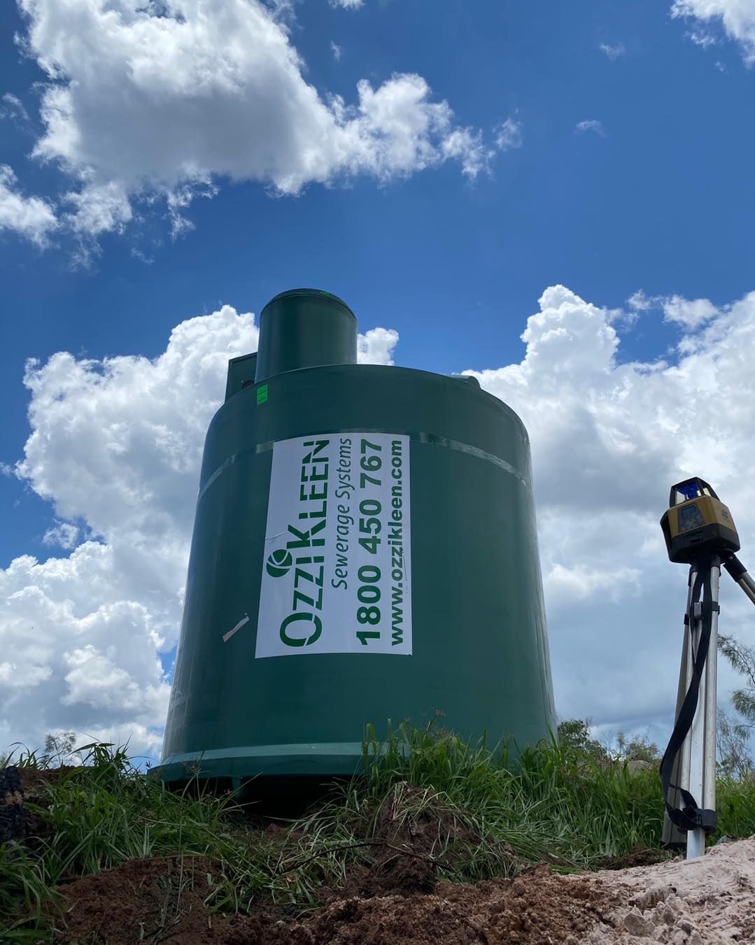 A Green Water Tower is Sitting in the Middle of a Field — Wigg Plumbing in Berrimah, NT