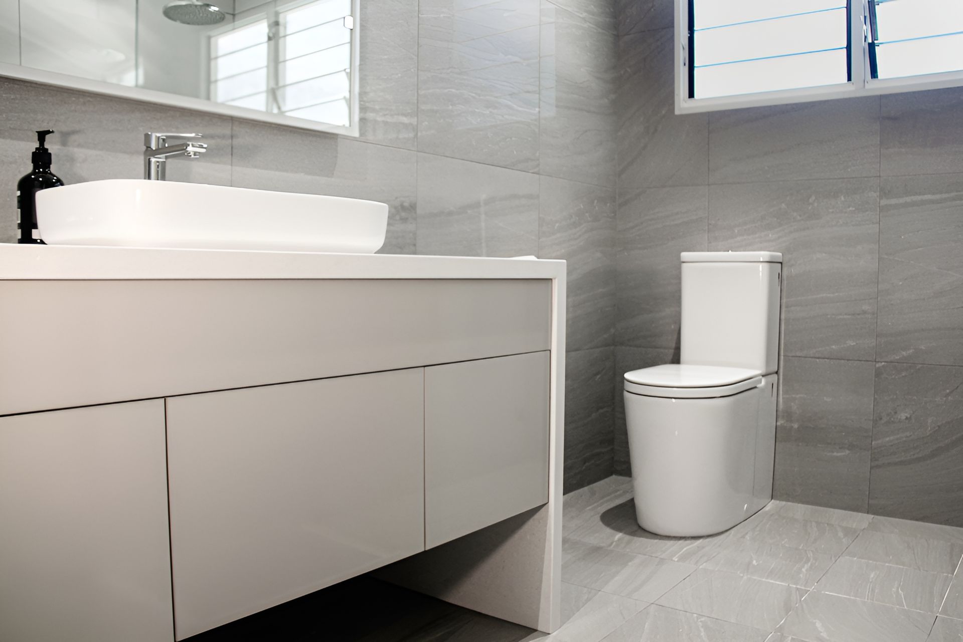 A Man Wearing a Cowboy Hat is Squatting on a Roof — Wigg Plumbing in Berrimah, NT