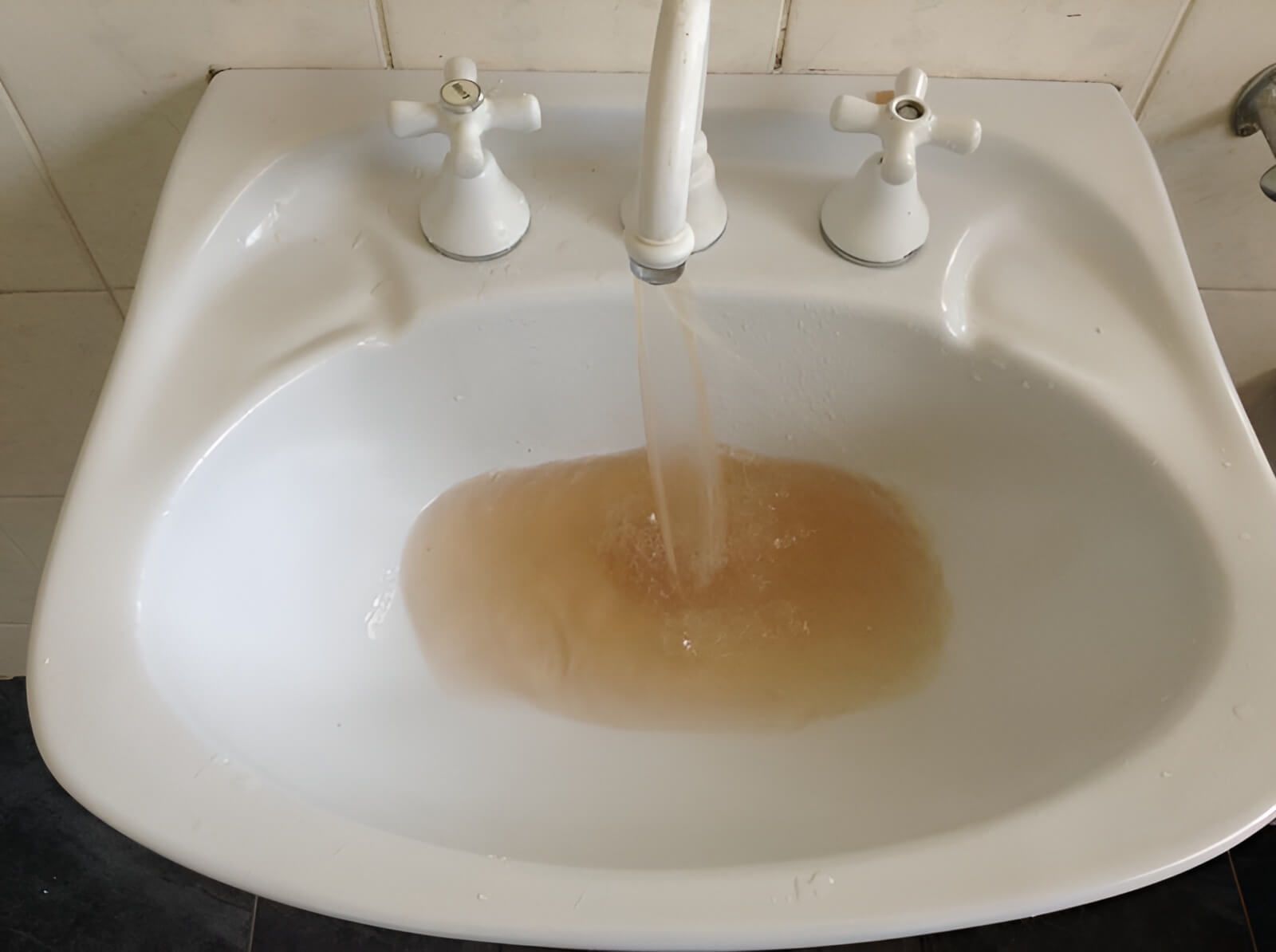 A White Sink With Brown Water Coming Out of the Faucet — Wigg Plumbing in Berrimah, NT