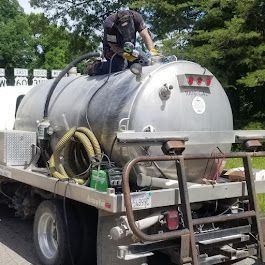 A man is sitting on top of a vacuum truck.