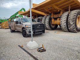 A truck is parked in front of a large dump truck.