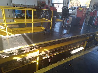 A garage with a yellow railing and a yellow ramp.
