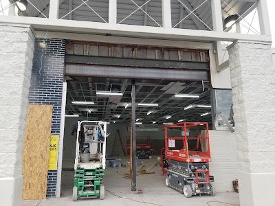 A forklift and scissor lift are parked in front of a building under construction.