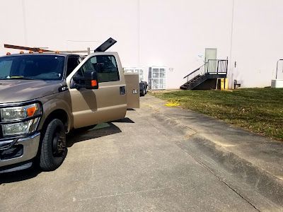 A truck is parked on the side of the road in front of a building.