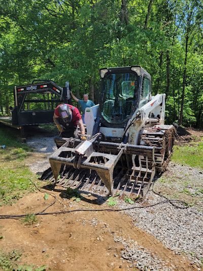 A man is standing next to a bulldozer on a dirt road.