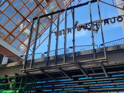 A large sign is being installed on the side of a building.