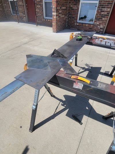 A person is cutting a piece of metal on a workbench.
