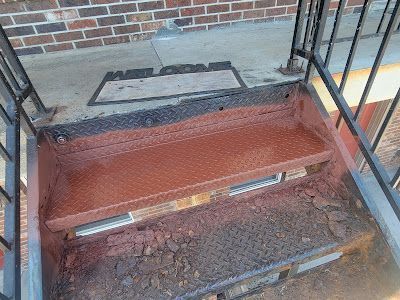 A set of stairs with a brick building in the background.