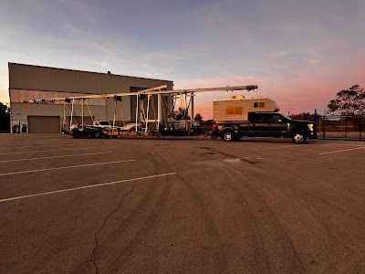 A truck is parked in a parking lot in front of a building.