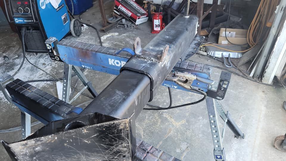 A piece of metal is sitting on top of a workbench in a garage.