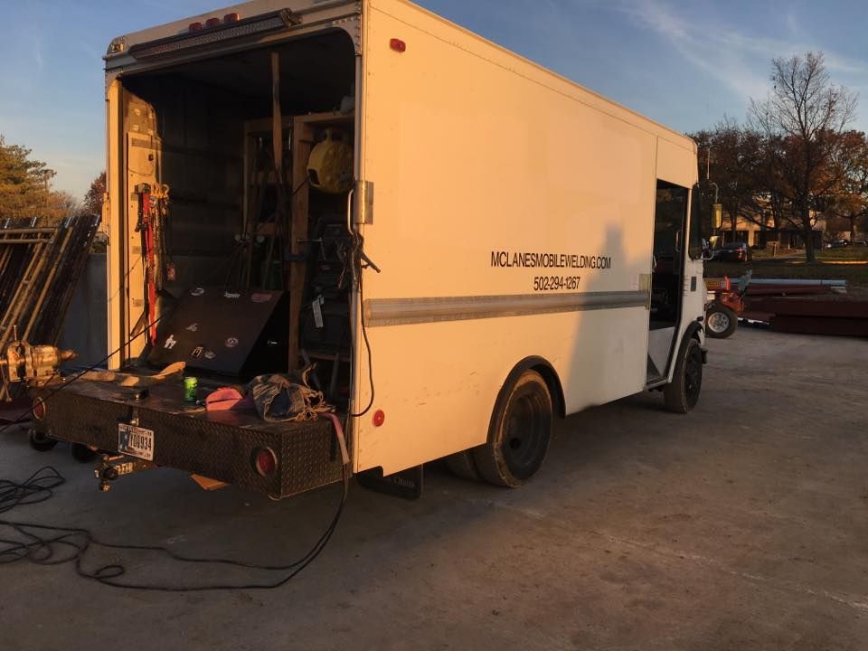 A white truck is parked in a parking lot with the door open