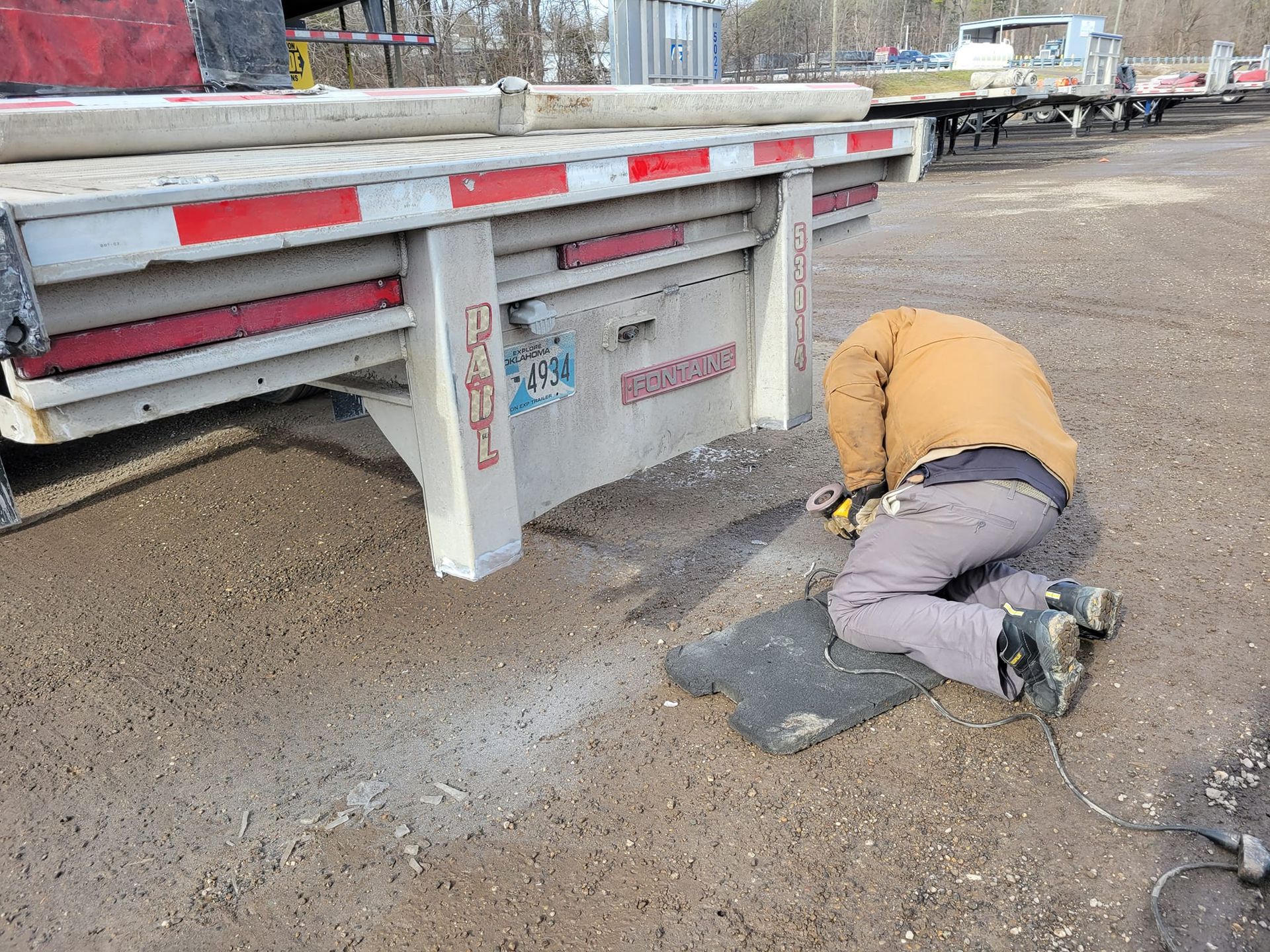 A man is working on the back of a semi truck
