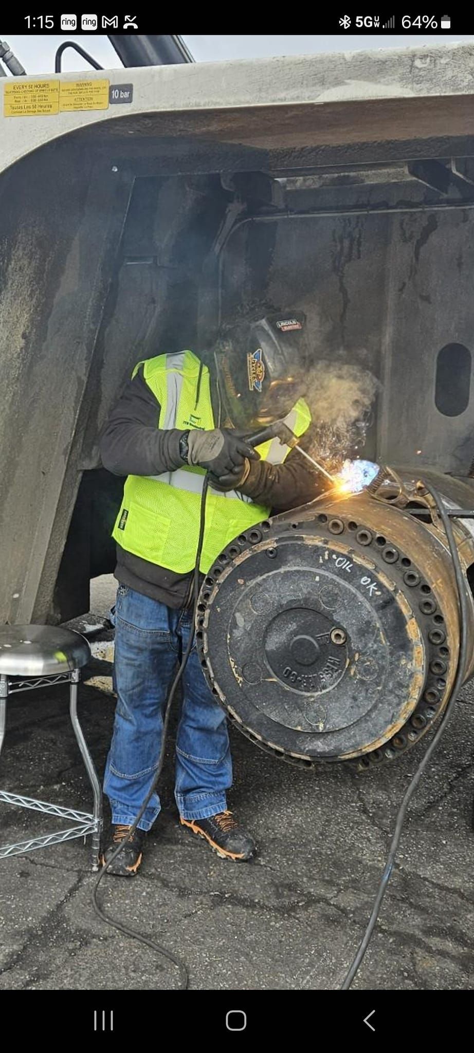 A man is welding a tire on a truck.