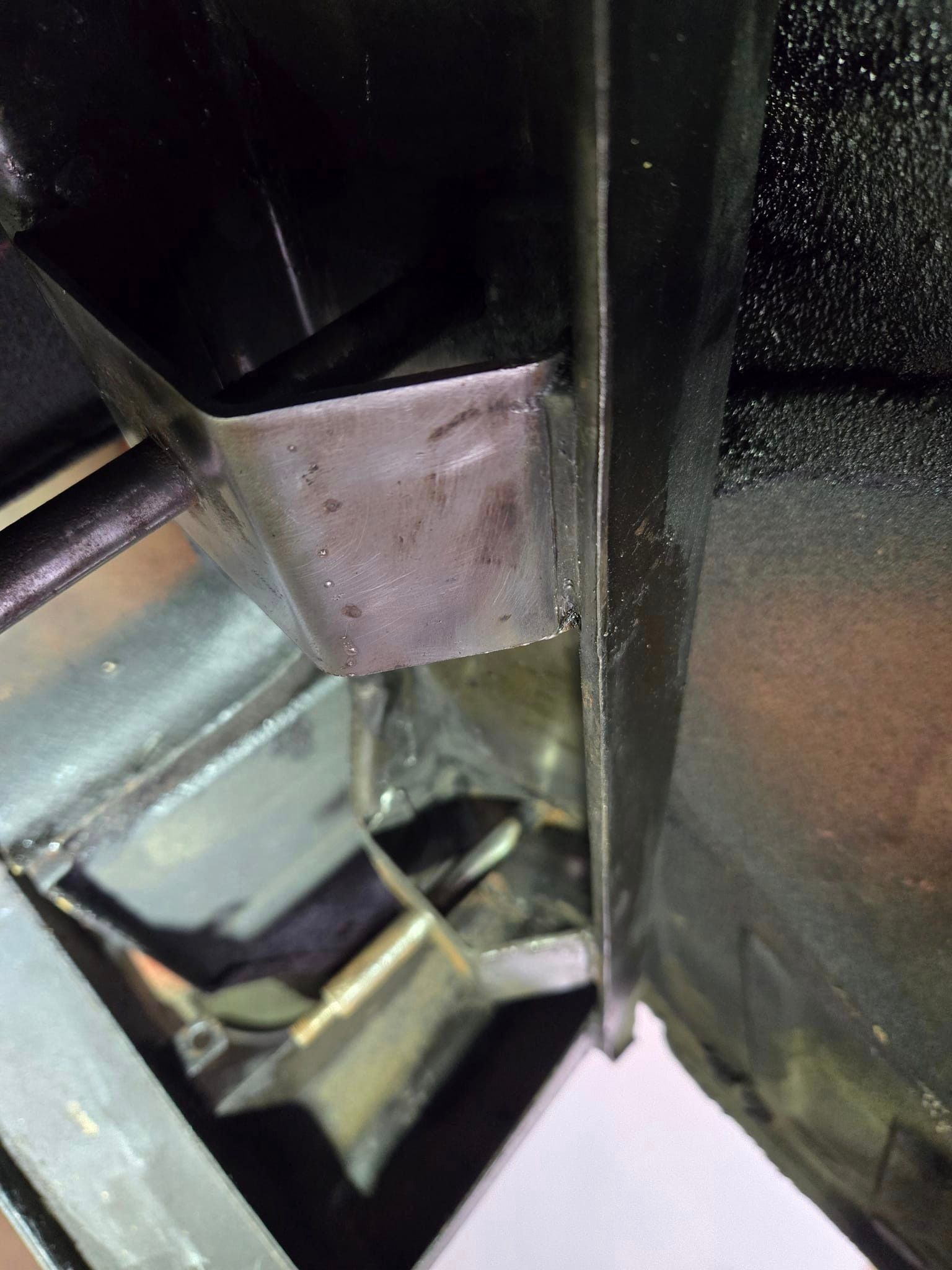 A close up of a metal bracket on the side of a car.