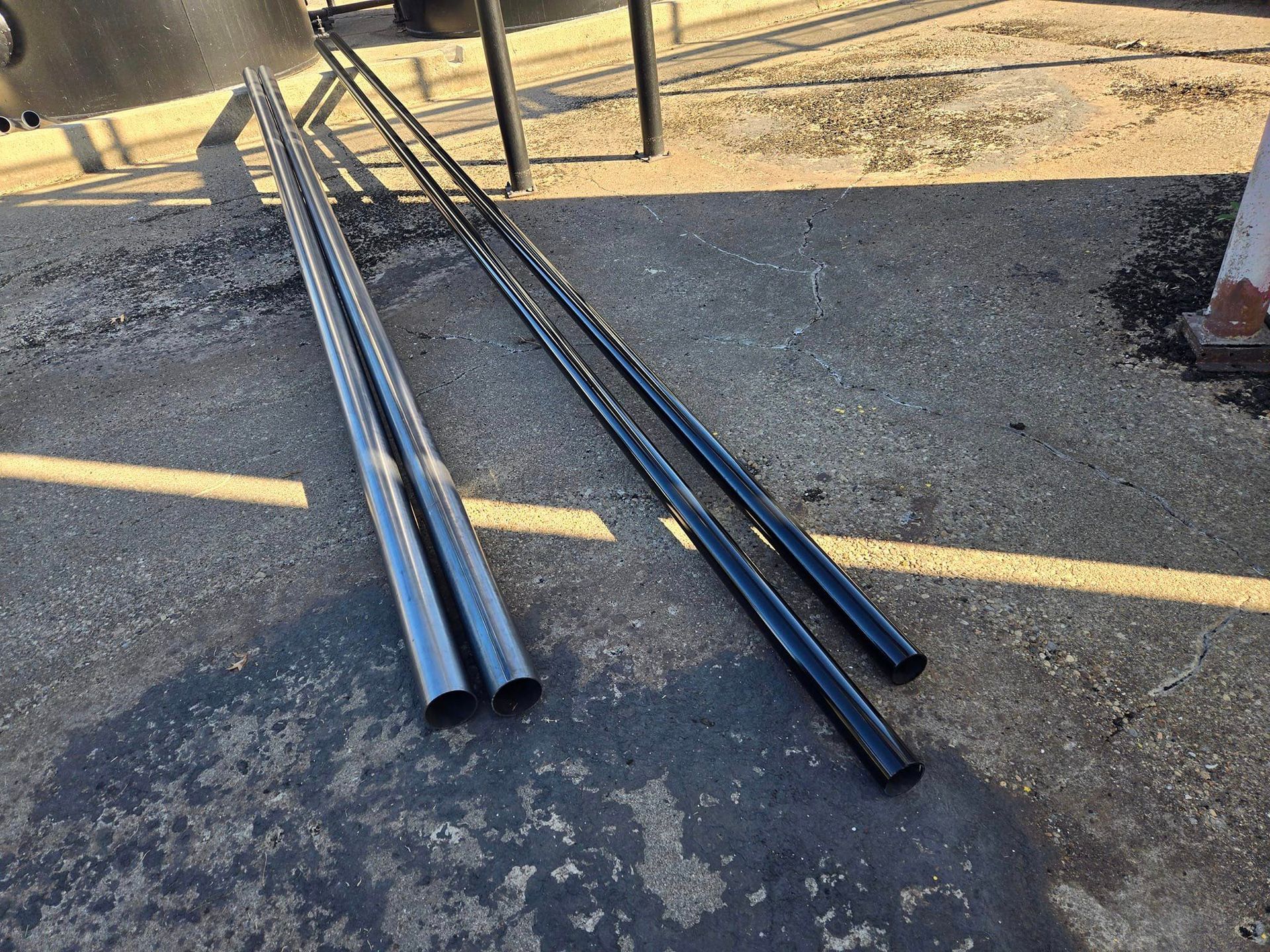 A bunch of metal pipes are laying on the ground
