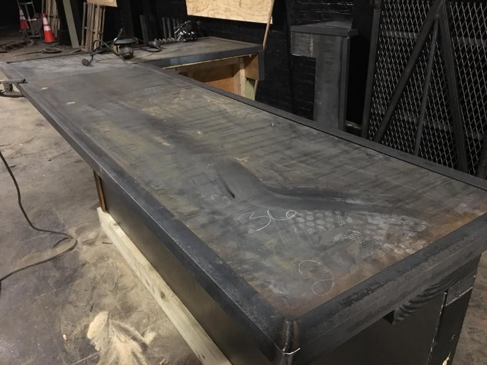 A large metal table is sitting on top of a wooden table.