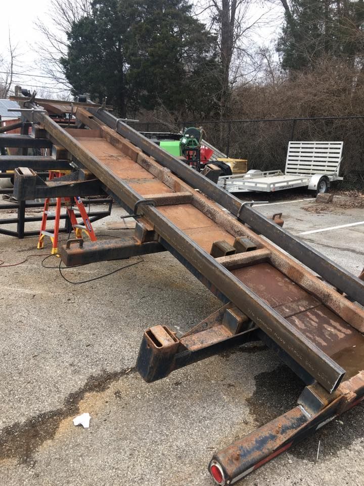 A metal ramp is sitting on the ground in a parking lot.