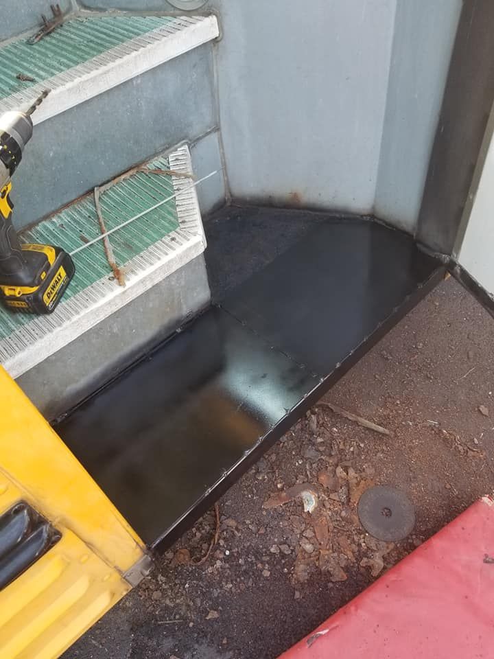 A person is using a drill on a staircase.