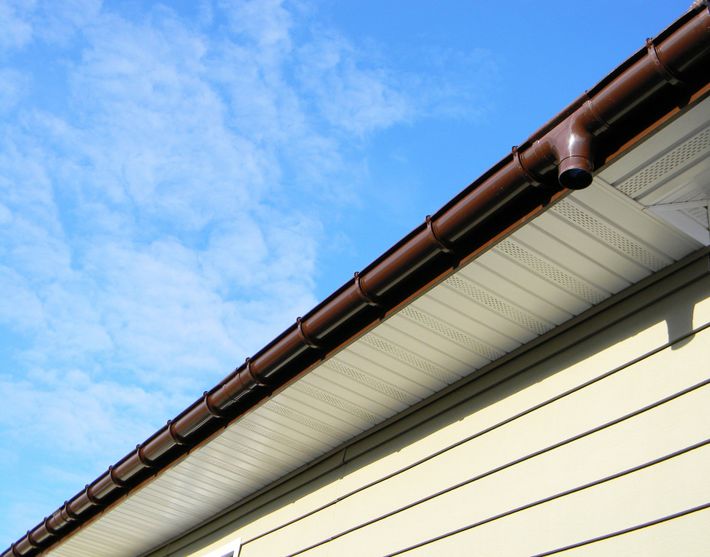white siding & soffits with metal gutters