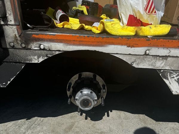 A close up of a truck 's wheel with a yellow towel on top of it.