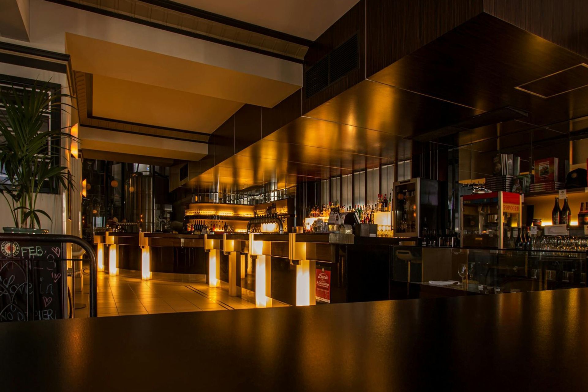 A restaurant with a long bar and a table in the foreground. A restaurant with a long bar and a table in the foreground.