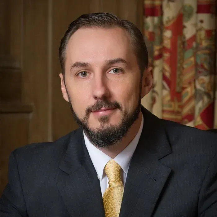 Man in a suit and tie with a beard; formal portrait.