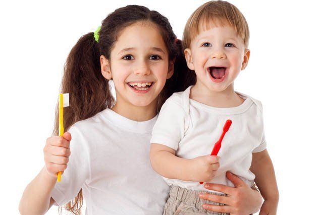 young boy and girl holding toothbrushes