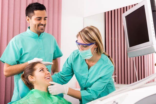 dentist and dental assistant consulting patient