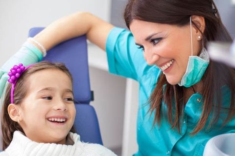 female dentist reassuring young girl