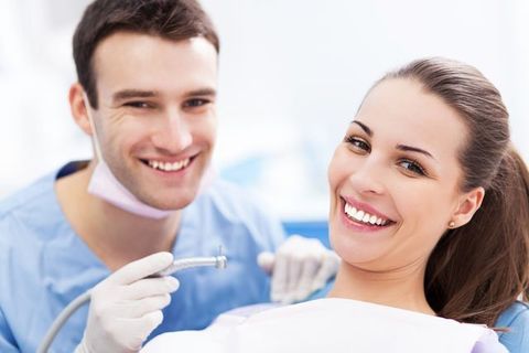 young male dentist with female patient
