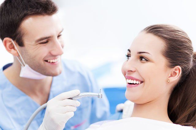 dentist smiling with patient in dental chair