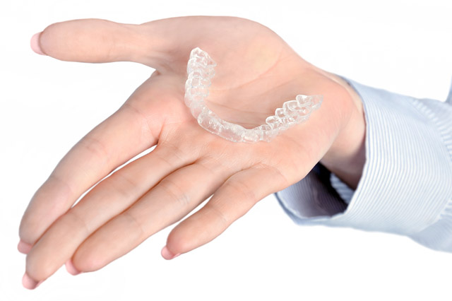 woman's hand holding mouthguard
