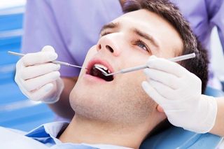 dentist looking in male patients mouth