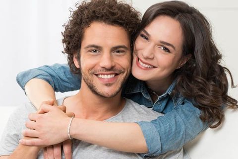happy young couple on lounge woman standing behind