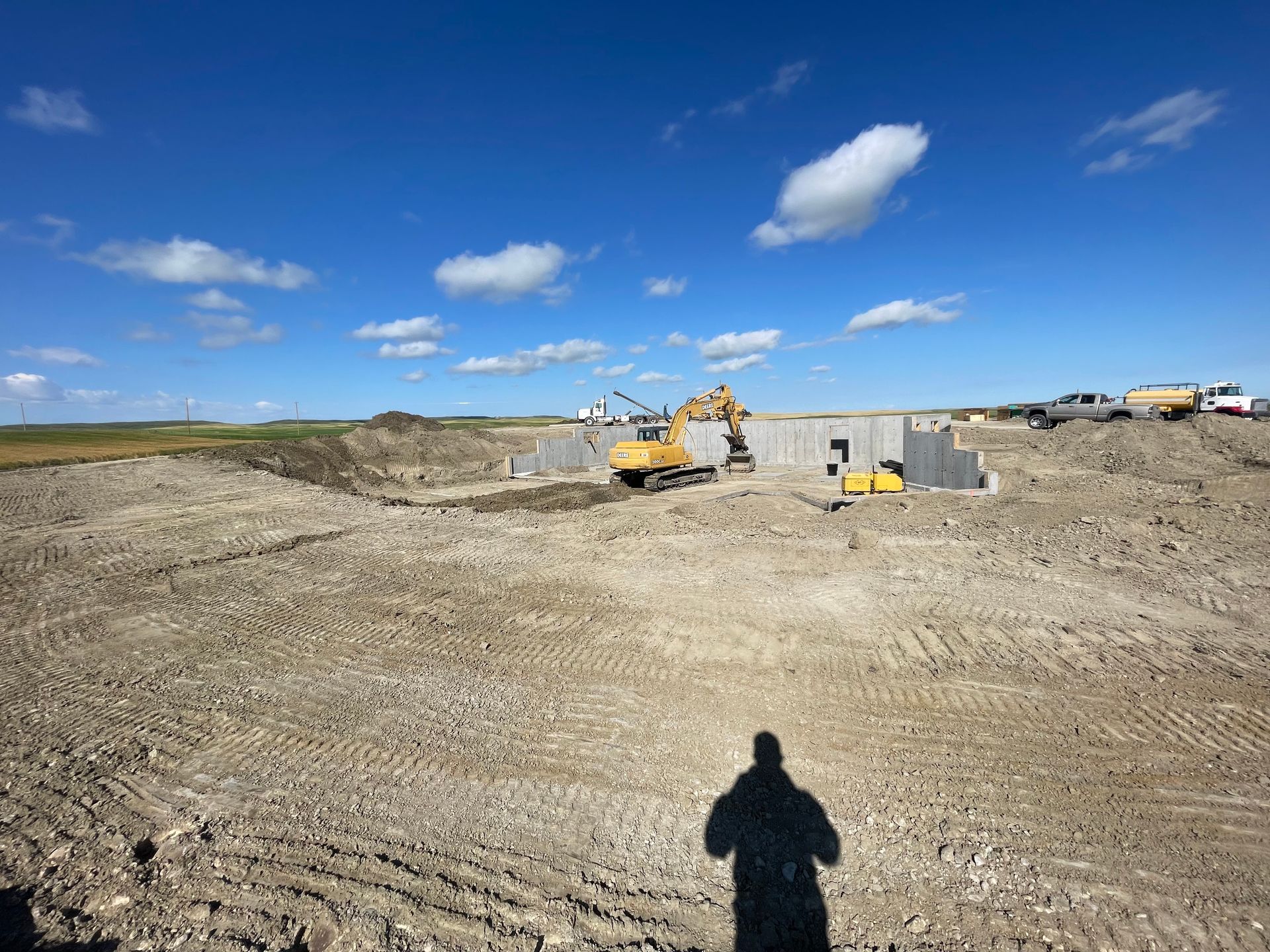 A construction site with a shadow of a person in the dirt.