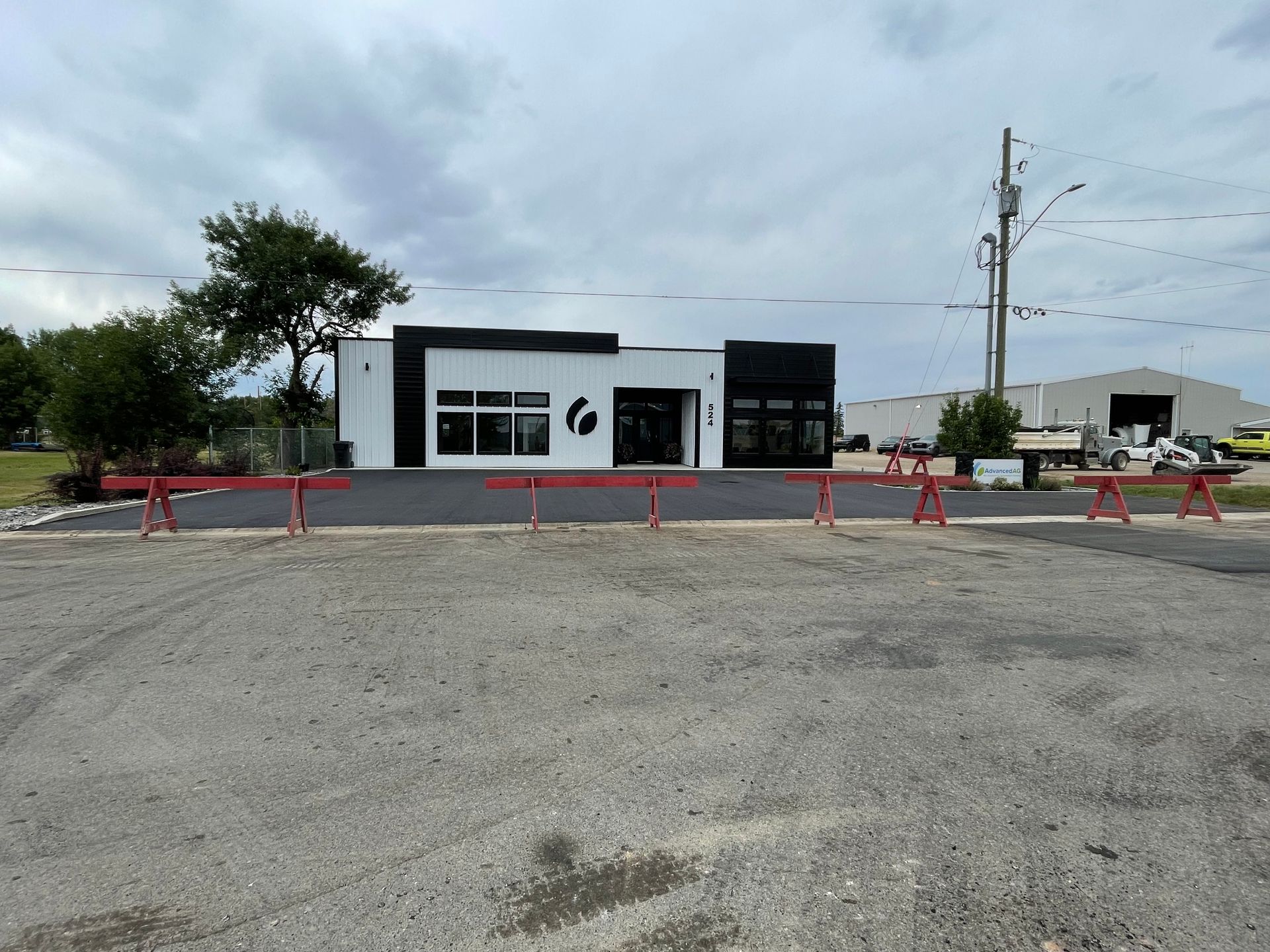 A black and white building with a red fence in front of it