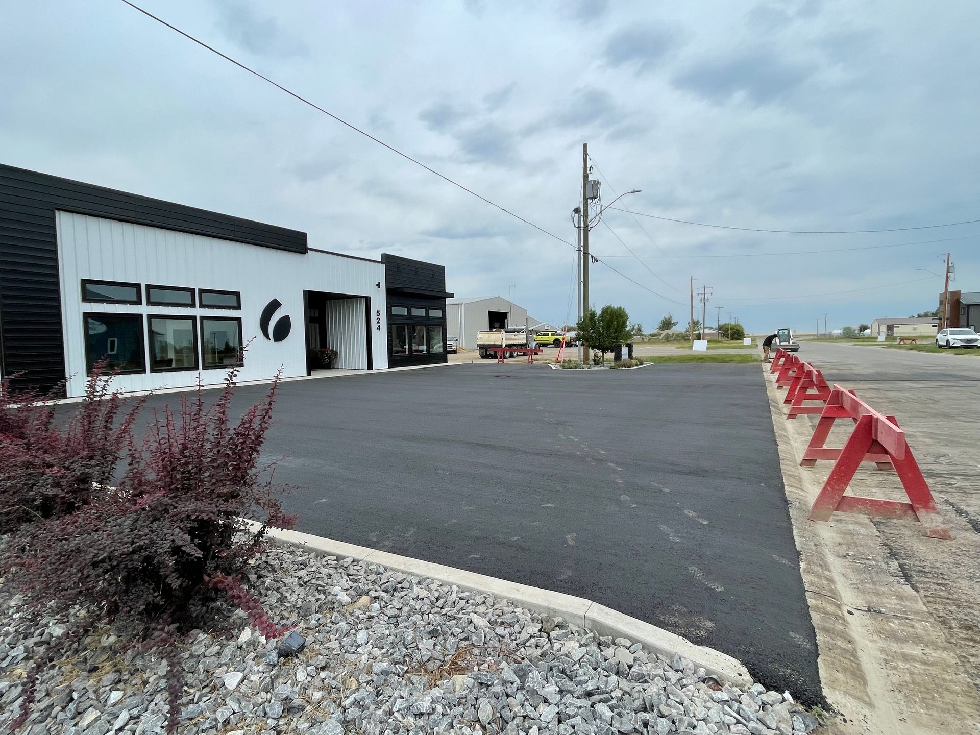 A black and white building with a parking lot in front of it.