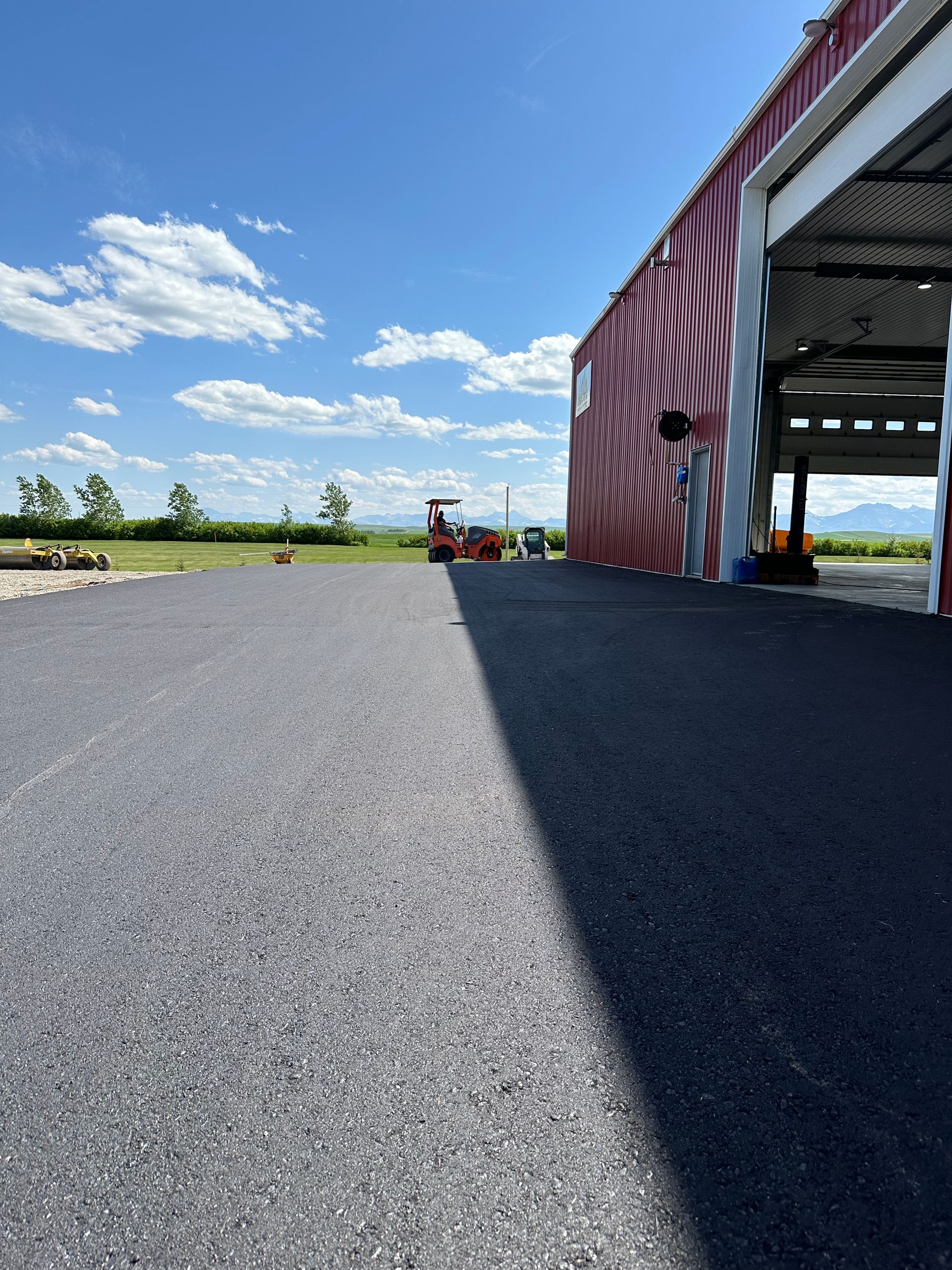 A person is standing in front of a building with a red and white wall.