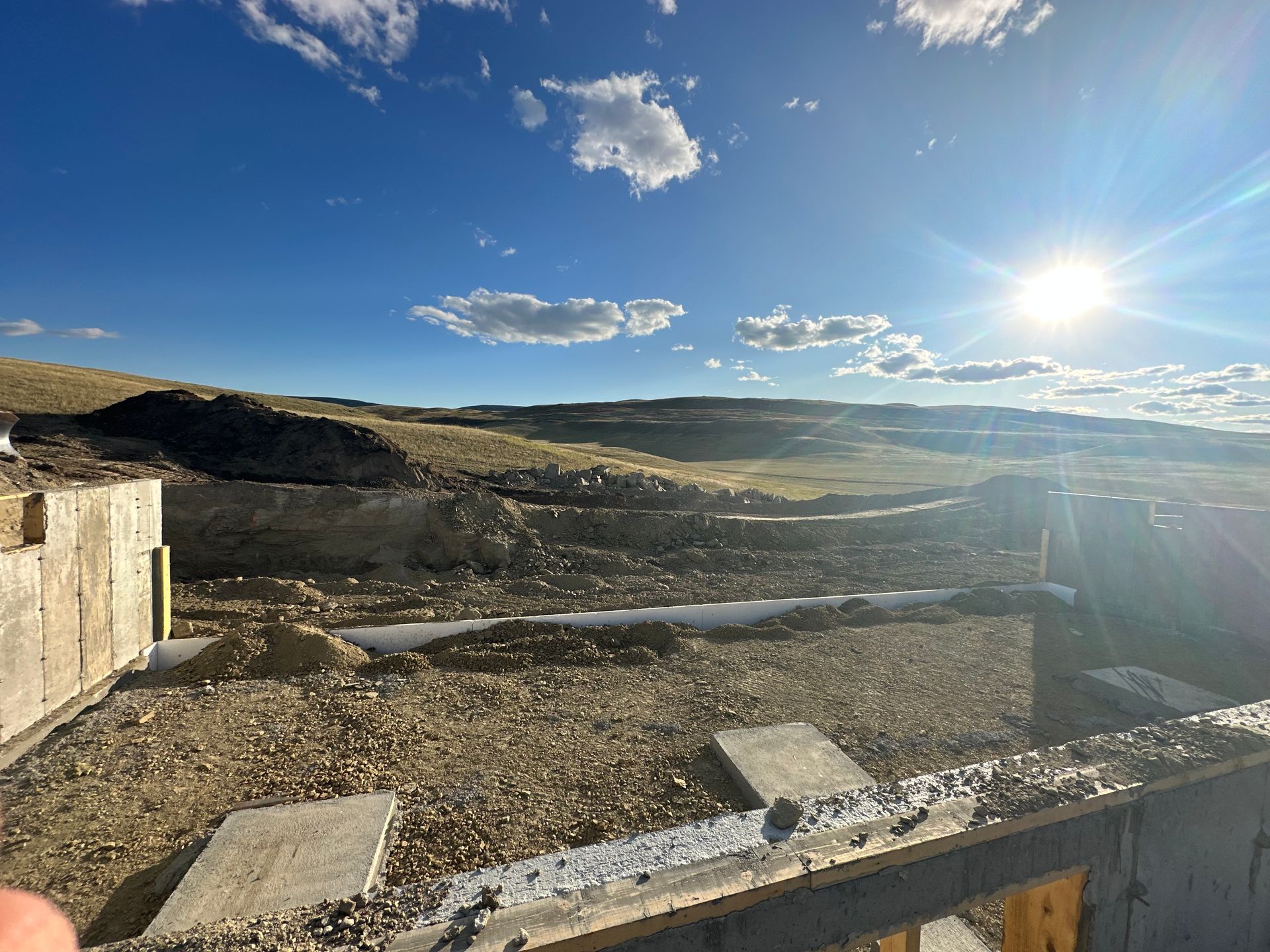 The sun is shining through the clouds over a construction site