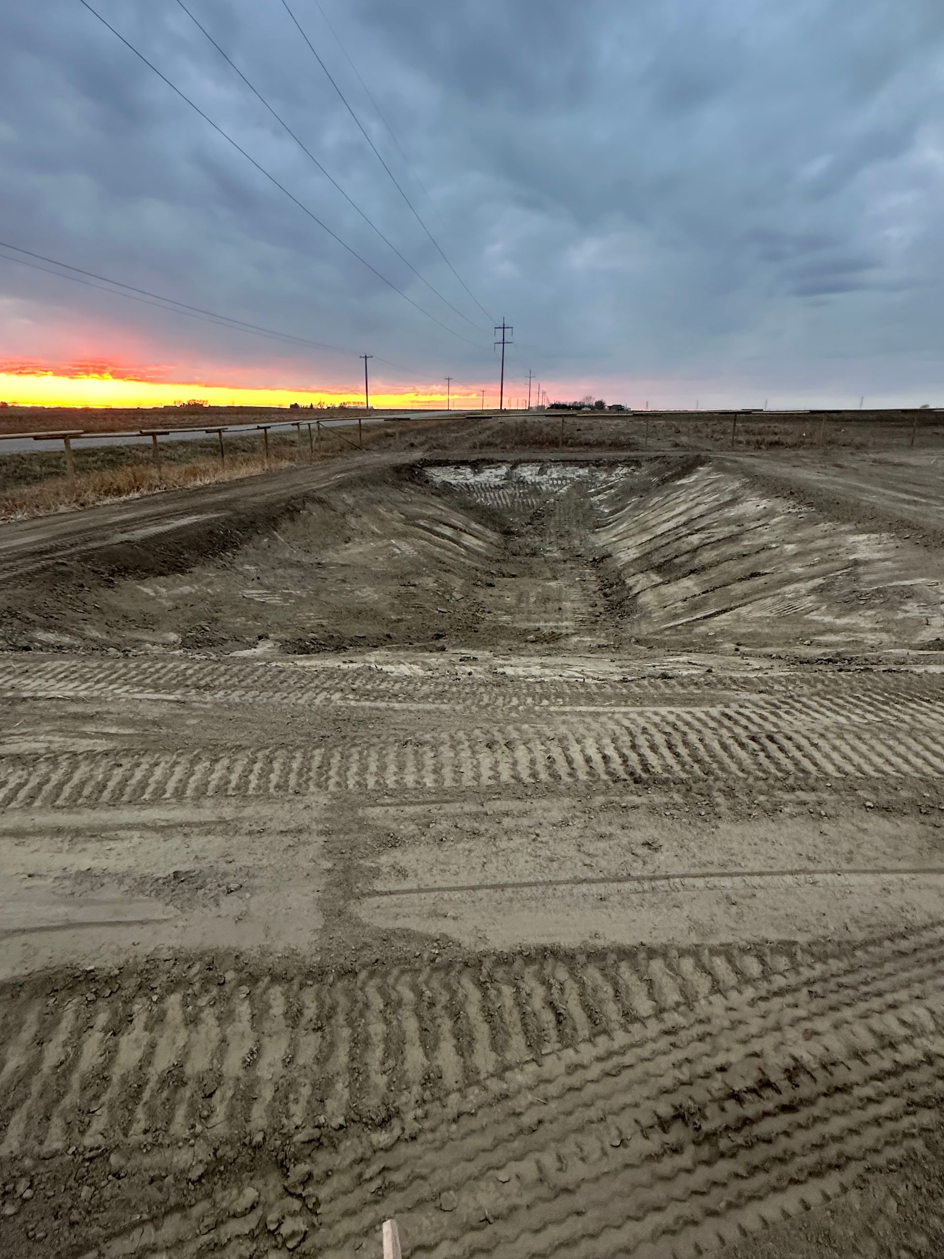 A large dirt field with a sunset in the background.