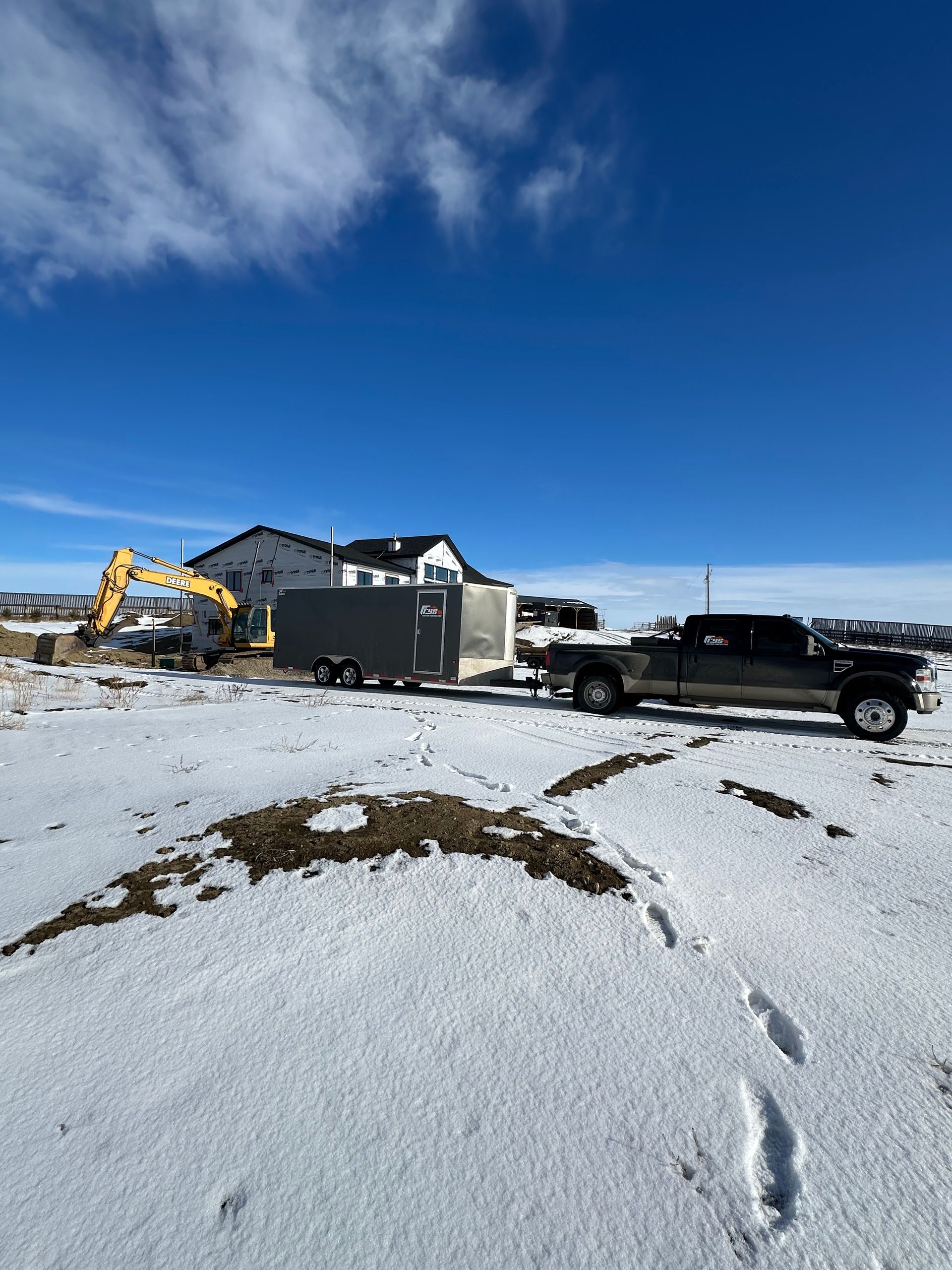 A truck is towing a trailer in the snow.