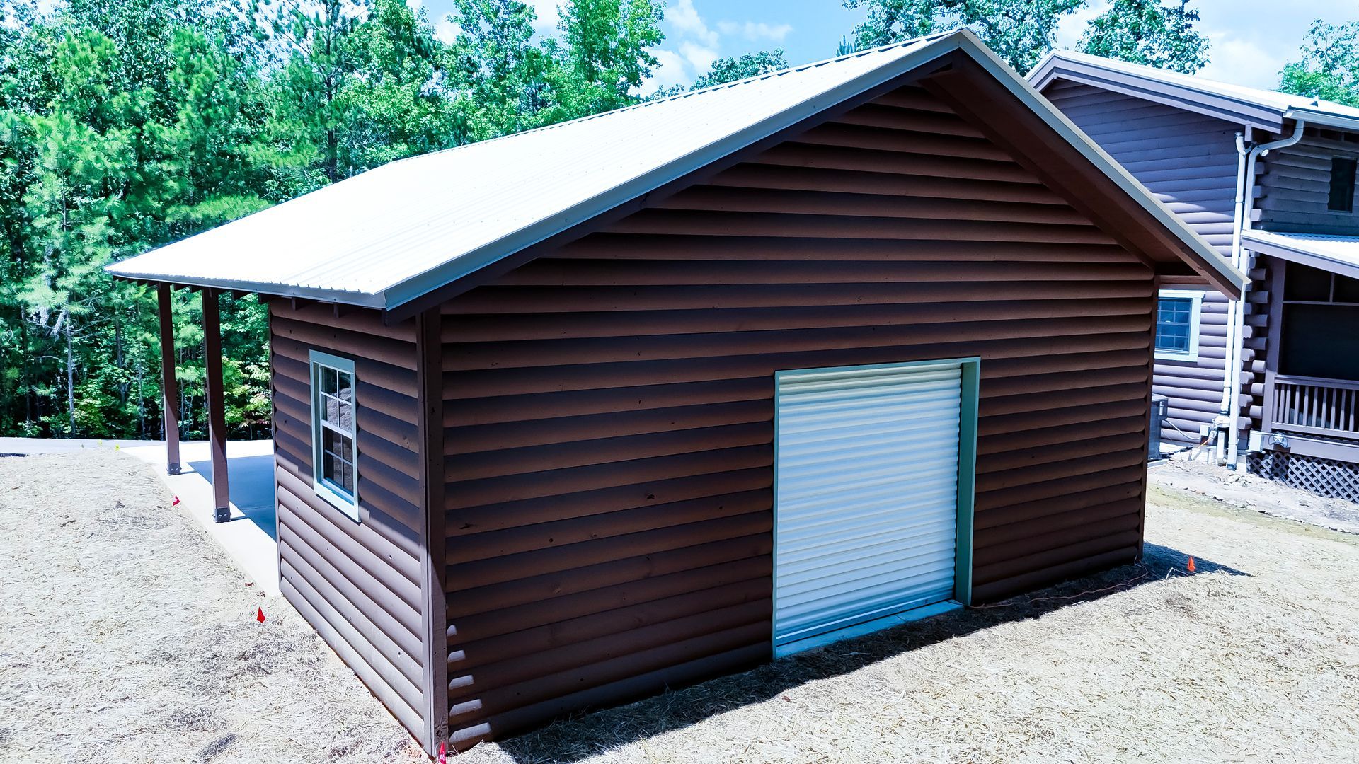 A log cabin with a white roof and a garage door