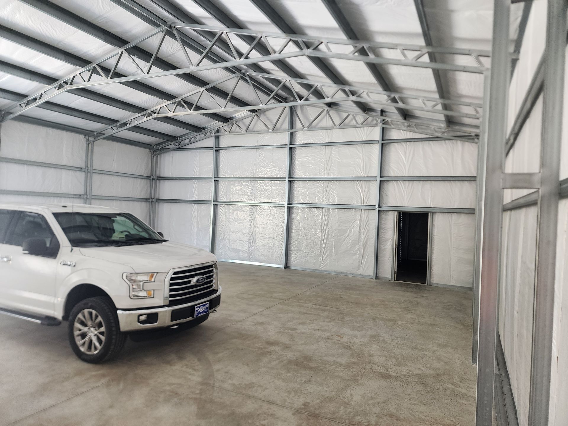An aerial view of a garage with a car parked in front of it.