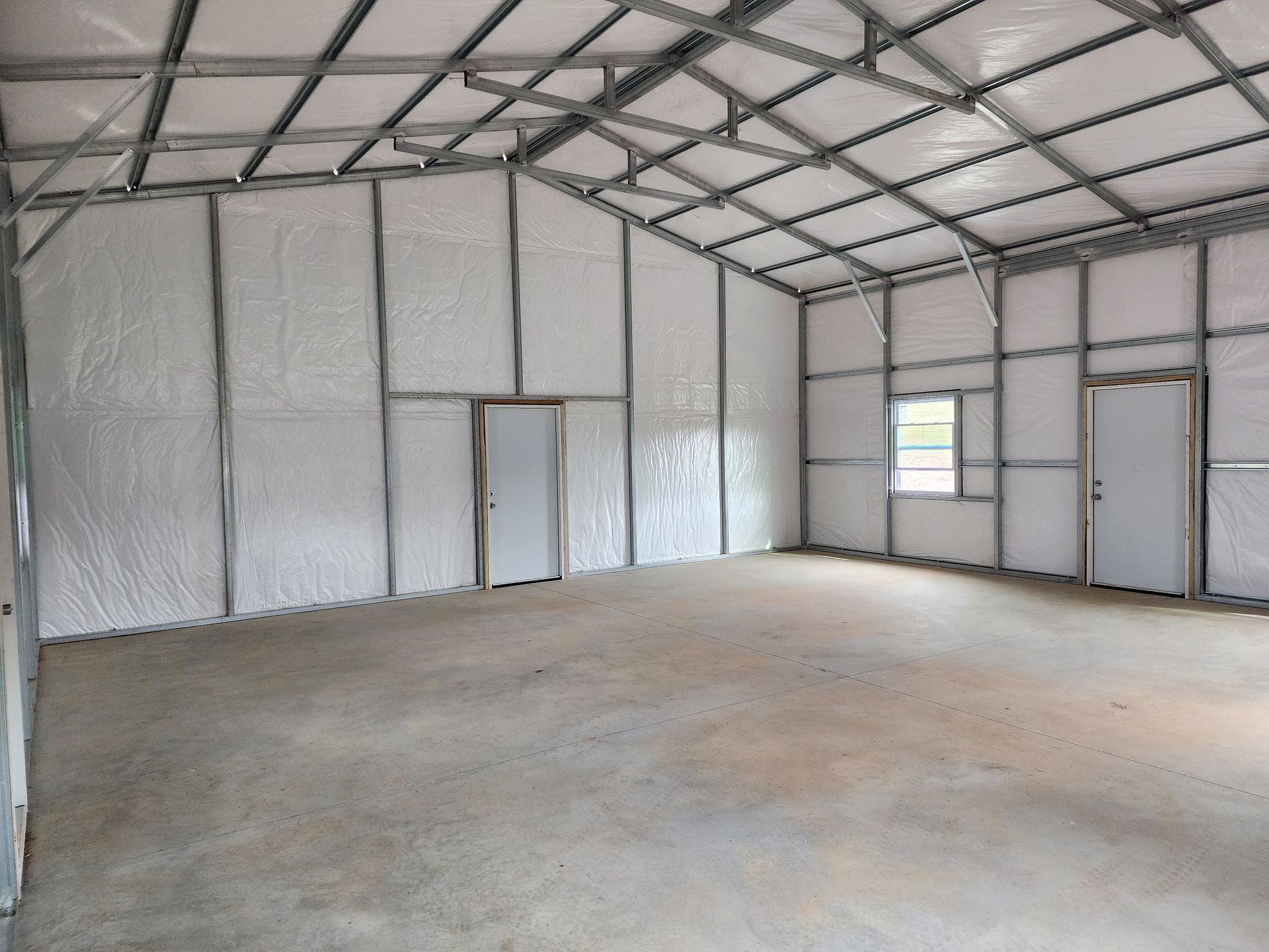 A large empty building with white walls and a window.